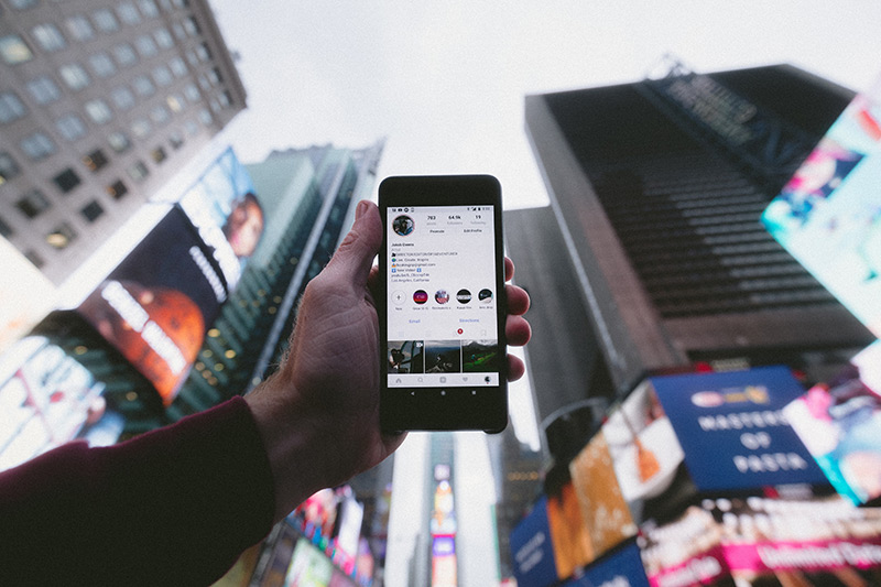 Instagram Business Marketing, holding phone in city background